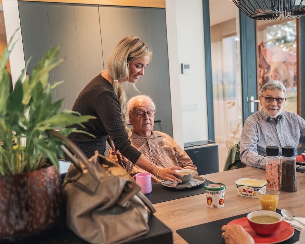 medewerker serveert soep aan bewoners