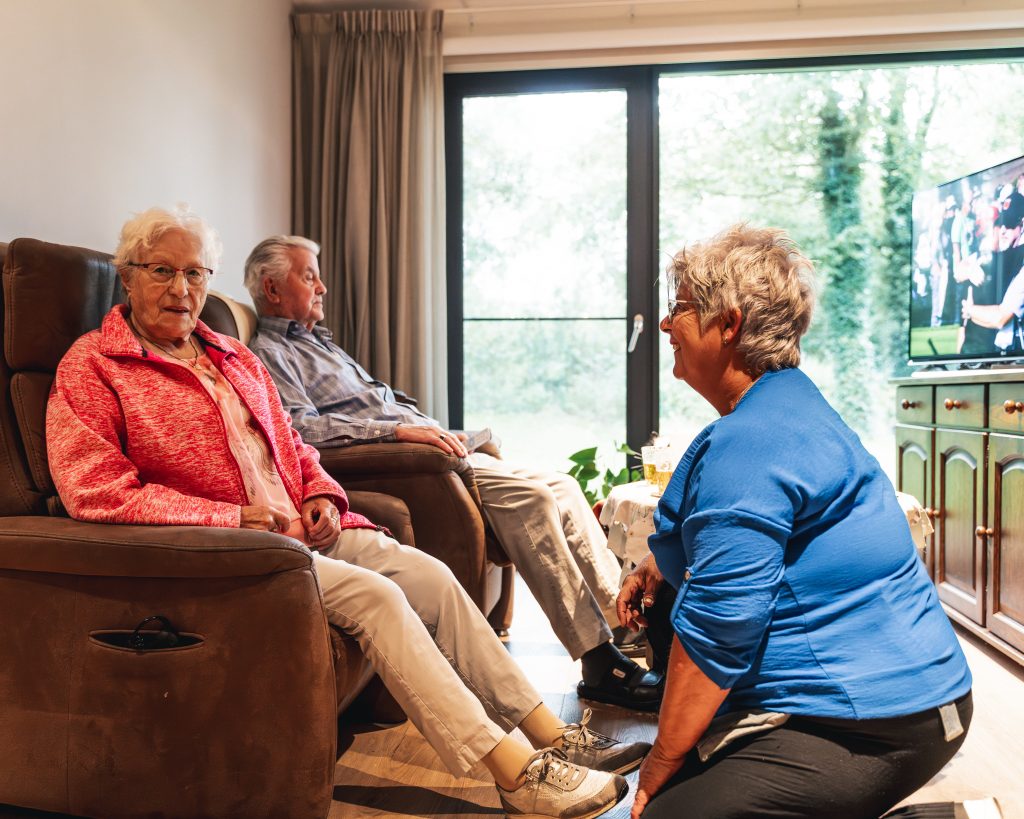Verzorger helpt bewoner met de schoenen