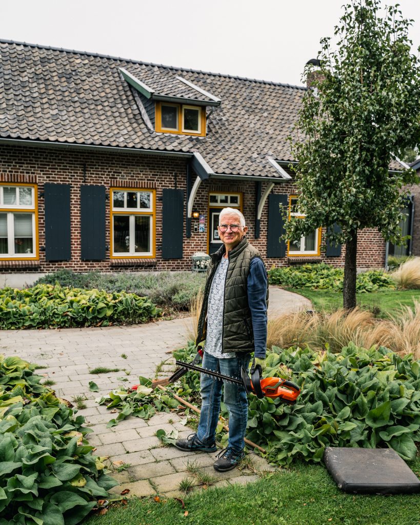 Tuinier in tuin van zorghuis