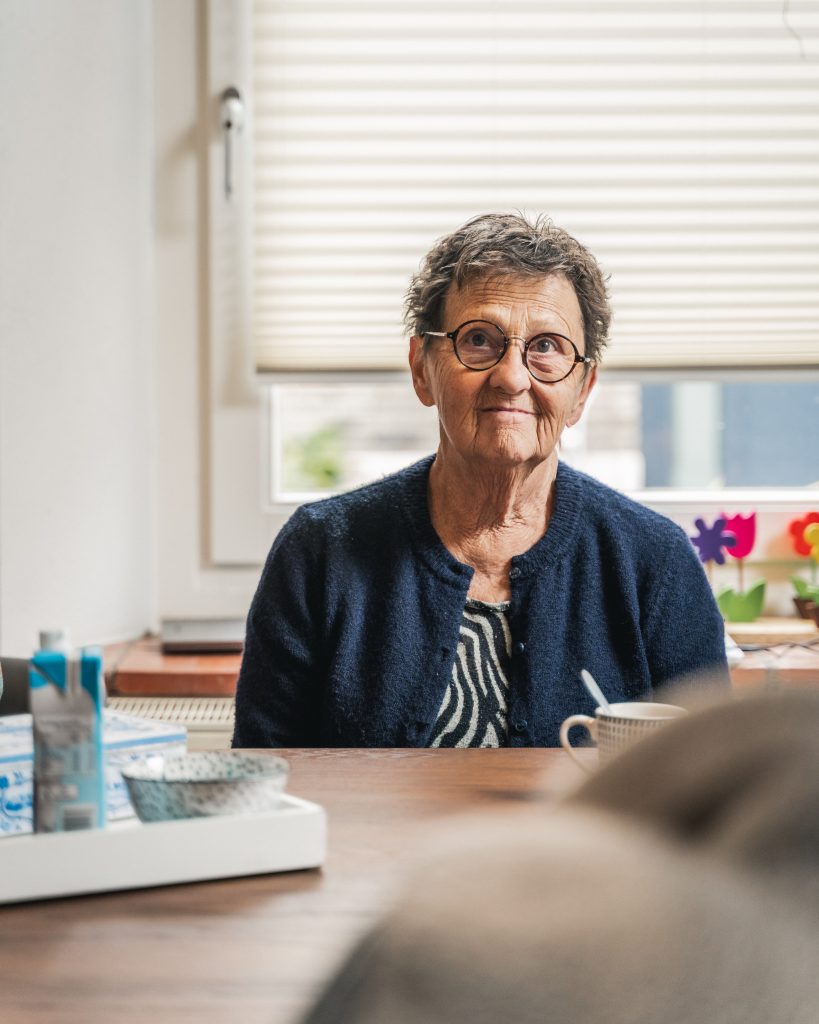 Lachende oudere vrouw aan tafel