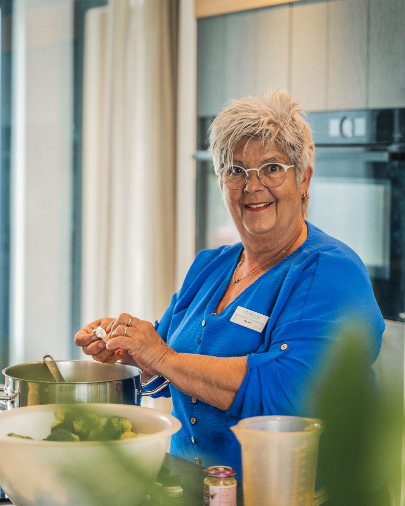 Lachende medewerker tijdens het koken