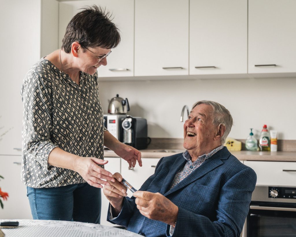 Vrolijke ouderen in de keuken aan tafel