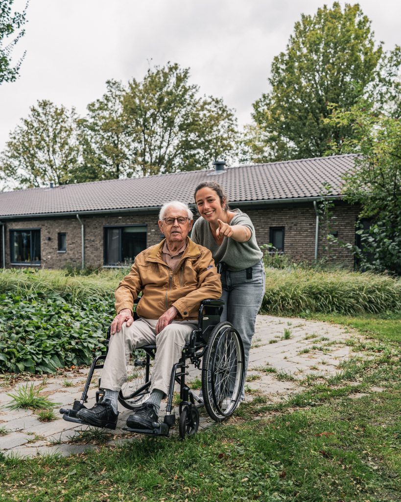 Lachende verzorger met bewoner in rolstoel